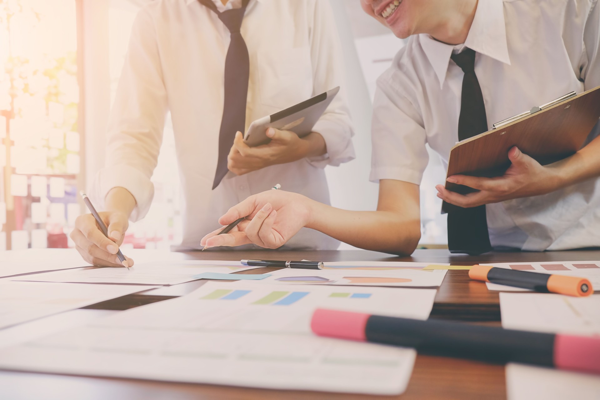 Concetto di incontro di lavoro, due persone che pianificano i dati statici aziendali riportano sulla scrivania con tono vintage.